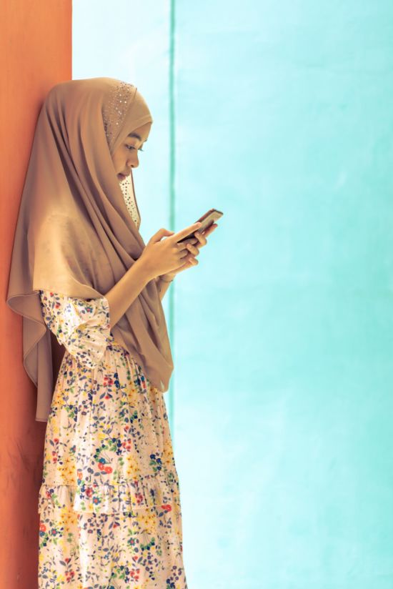 On the phone in Thailand: Because mobile devices may be of limited utility for online learning and work purposes, computer ownership should be affordable and guaranteed (Credit: vichie81 / Shutterstock.com)